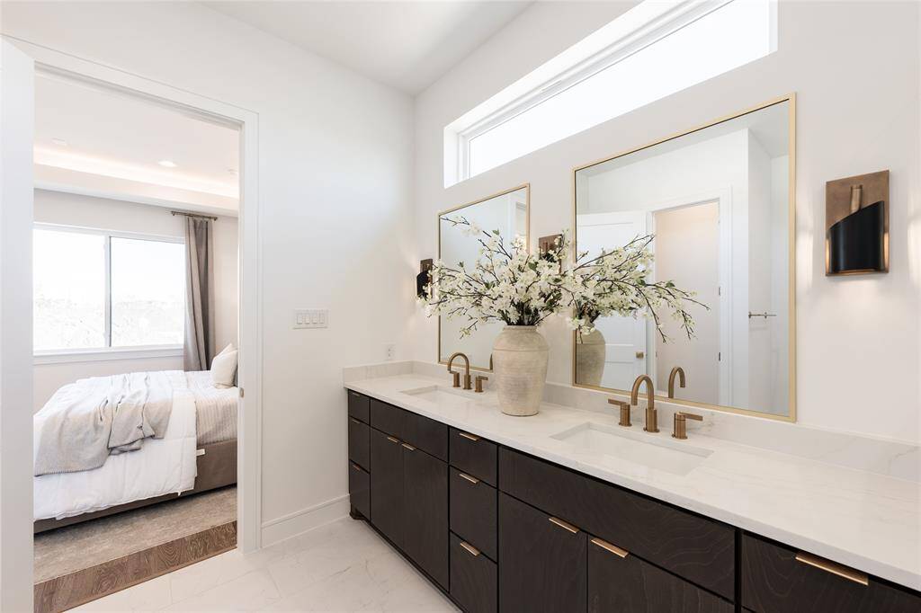 Custom vanities, high-end fixtures, and seamless lighting create a refined bathing experience.