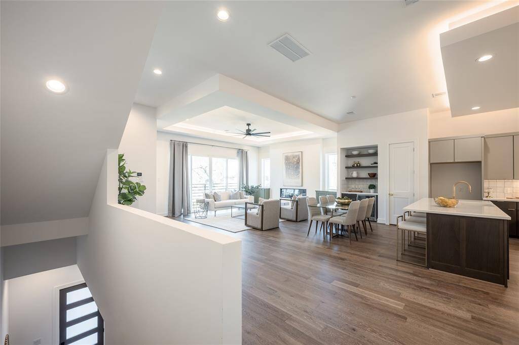 A dramatic dropdown ceiling with integrated lighting adds depth and dimension to this open-concept space.