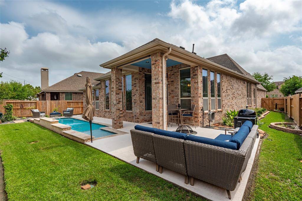 The home is fully bricked on all 4-sides with impeccable landscaping and detailed finishes. The extended patio includes comfortable seating, exterior light features and a covered section ideal for outdoor entertaining. The surrounding yard is neatly landscaped with a privacy fence.