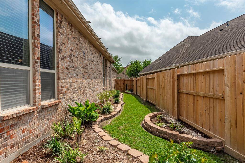The professionally landscaped yard features full gutters piped directly in-ground with hard PVC drains and drain grates.