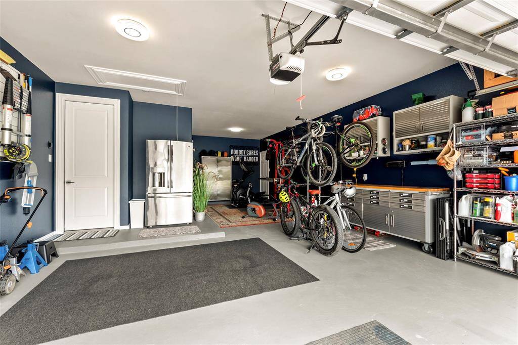 Clean!  Spacious!  Well-organized!  Attractive 3-car tandem garage with fresh paint, LED lights, organizing wall, cabinets and shelves (all included) and an exterior door which lead directly to the backyard. The GE French door refrigerator in the garage conveys too.  Sprinkler System control mount inside garage.