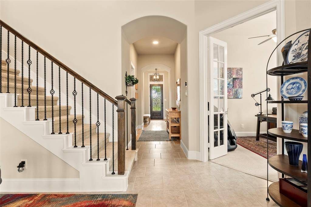 Green Built Gulf Coast Certified and Energy Star Appliances in this spaciousness, modern design 1.5-story home, featuring a bright entryway with elegant tile flooring and staircase with wrought iron railings.