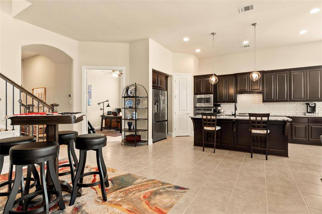 Spacious, open living kitchen and dining areas feature recessed canned lights, neutral paint tones and tile flooring throughout, giving the home a contemporary feel.