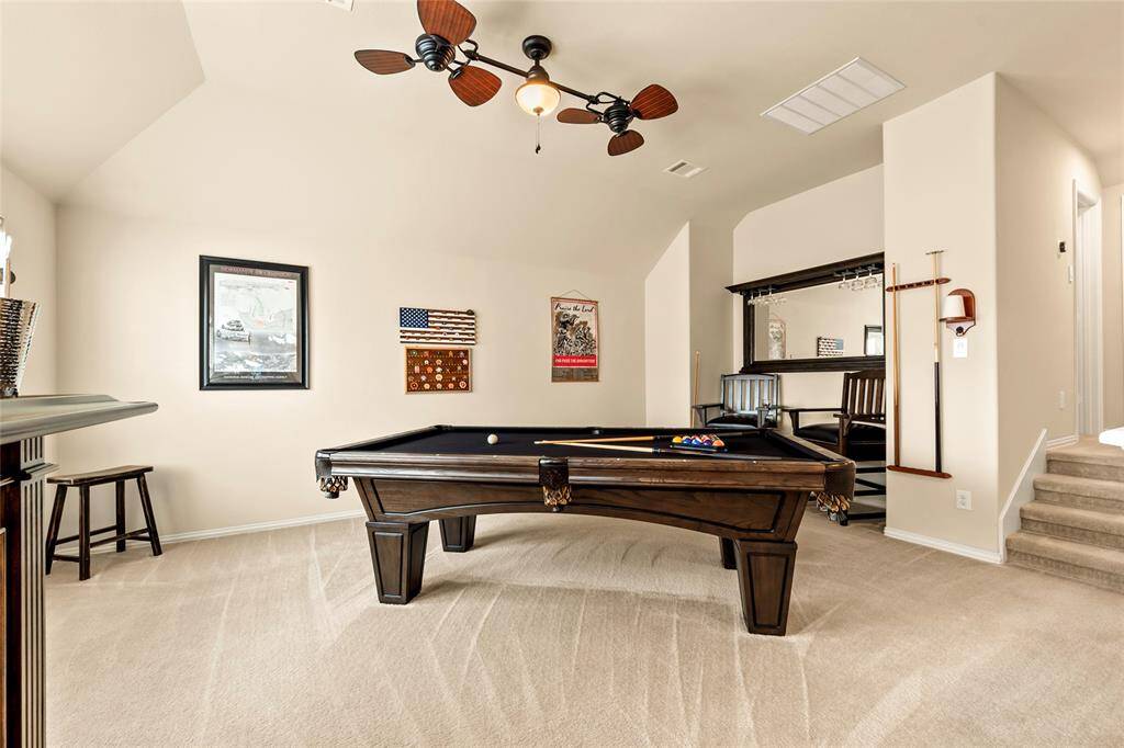 Upscale double ceiling fan, clean carpet, neutral paint tones and entertainment niche in the upstairs bedroom/gameroom.