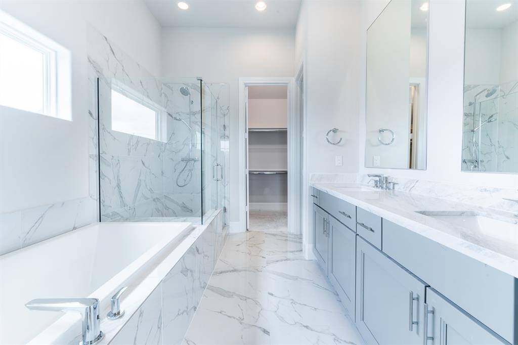 Light and bright!  Primary bath with nice tub and freestanding shower leading into 1 of 3 closets.Similar plan and finishes.