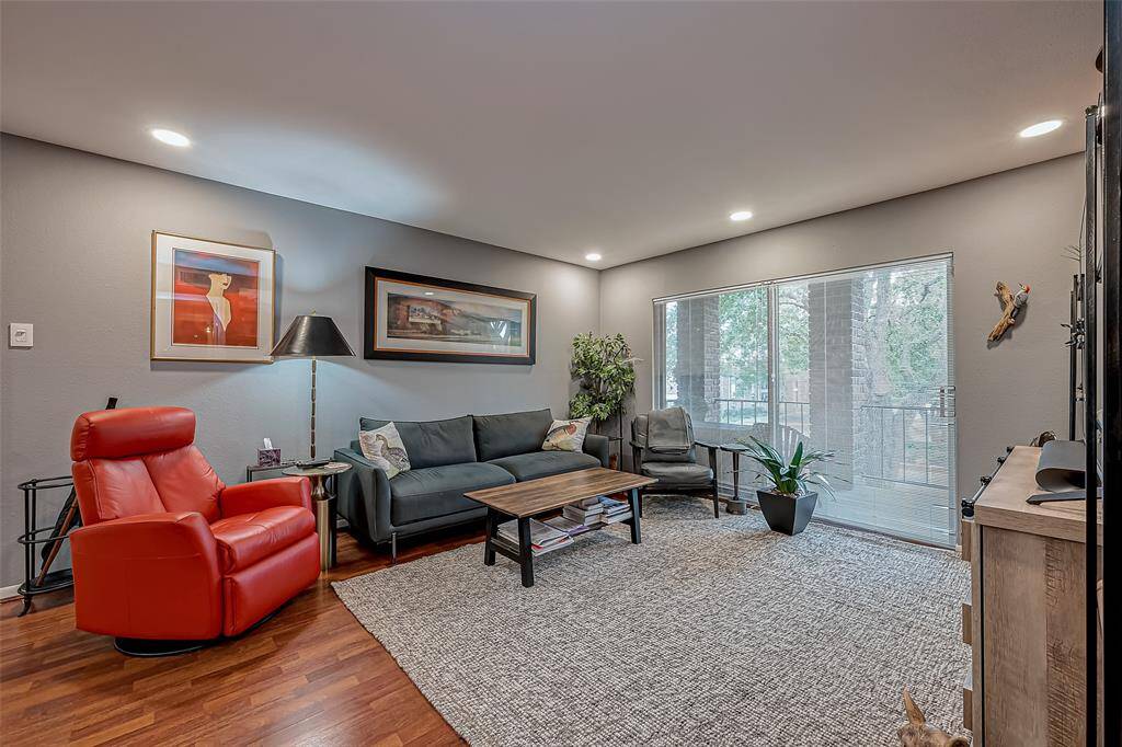 Warm and enviting living area with laminate wood flooring and large sliding glass doors to patio