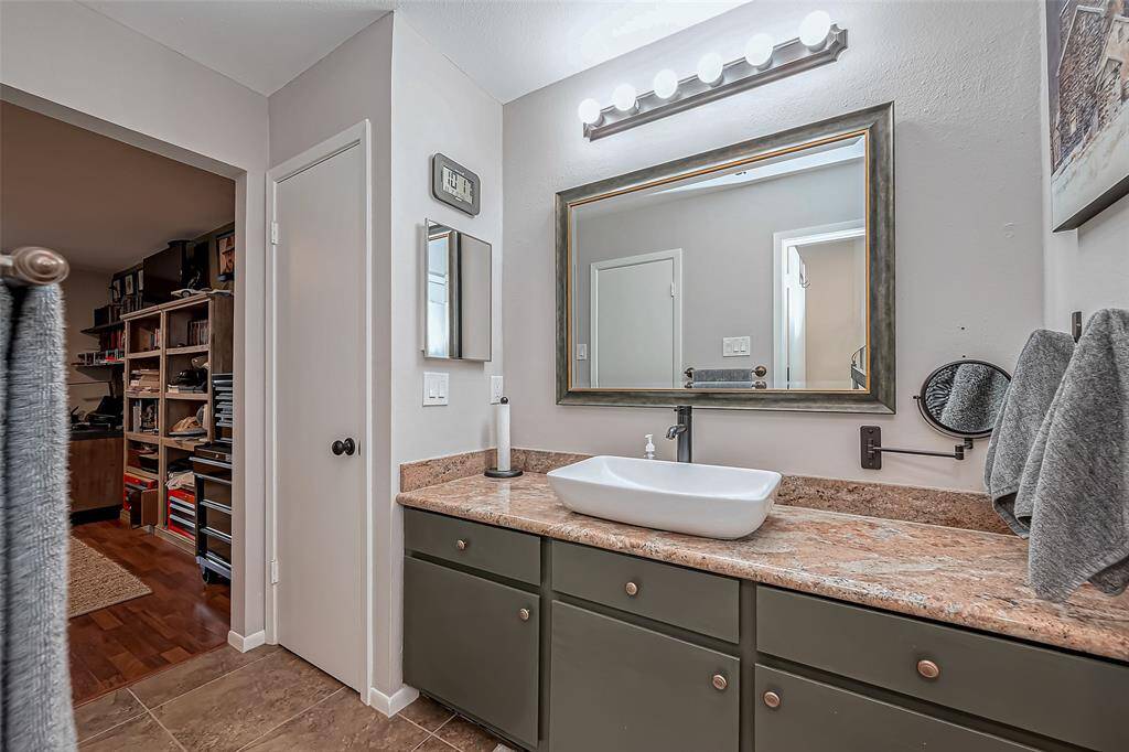 Primary bath has exotic granite with vessel sink and waterfall faucet.
