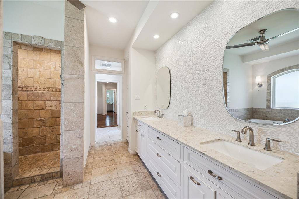 A beautiful mosaic tile backsplash behind the double sinks.