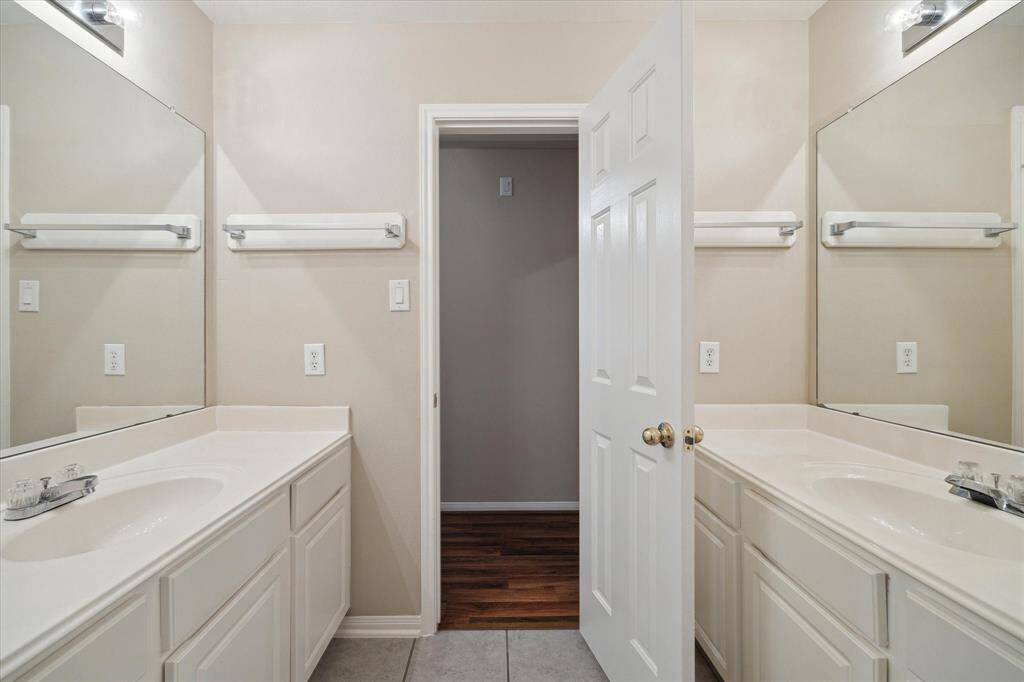 This view of the hall bathroom shows the two vanities and great storage in the cabinetry beneath each vanity top.  Towel bars are plentiful and are securely fastened to the walls with backer boards.