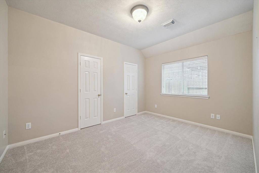 This spacious secondary bedroom has two closets and a window overlooking the side yard.  New carpet (April 2025) is cozy and quiet.  All bedrooms are wired for a light and a ceiling fan.