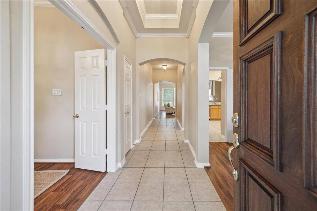 Welcome inside this impressive home through the solid wood paneled door. Upon entering you are surrounded with beautiful details like the vaulted tray ceiling, arch doorways, and classic crown molding.