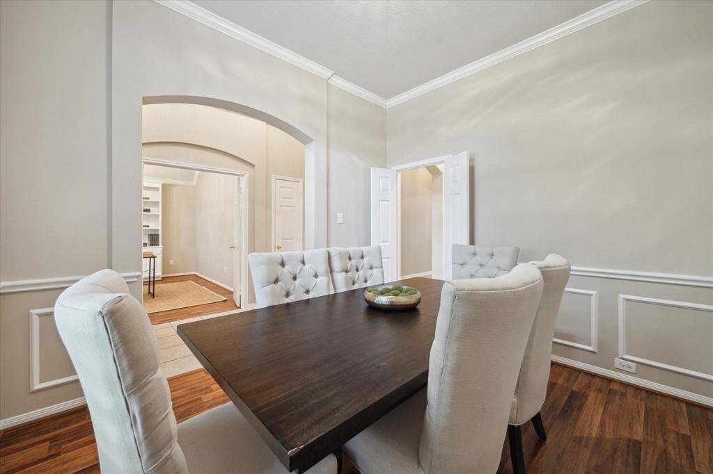 Notice the arched passageways of the dining room and in the home office beyond. Arched openings are found throughout this fine home.  Double doors on the right lead into the kitchen.