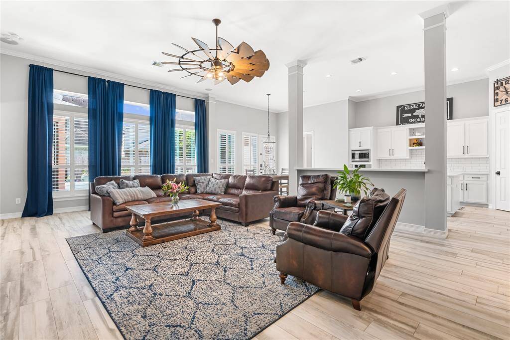 EXTRA-LARGE WINDMILL FAN IN THE LIVING ROOM.  NOTE THE CROWN MOLDING AND EXTRA WIDE BASEBOARDS THROUGHOUT THE HOME.