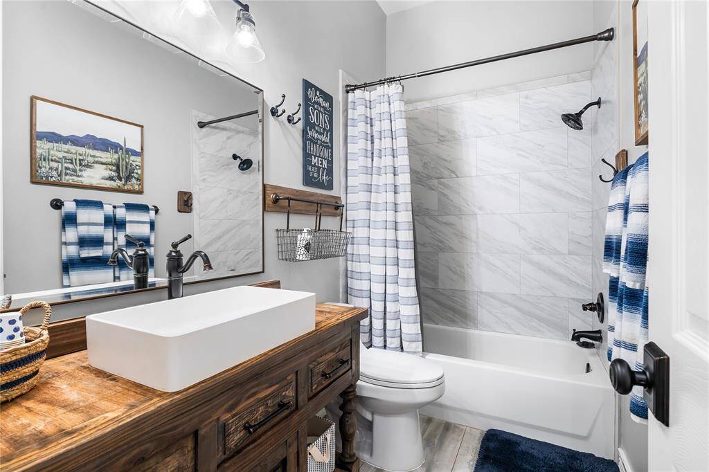EACH BATHROOM HAS IT'S OWN UNIQUE STYLE - THIS ONE FEATURES A DESIGNER VANITY WITH VESSEL SINK.
