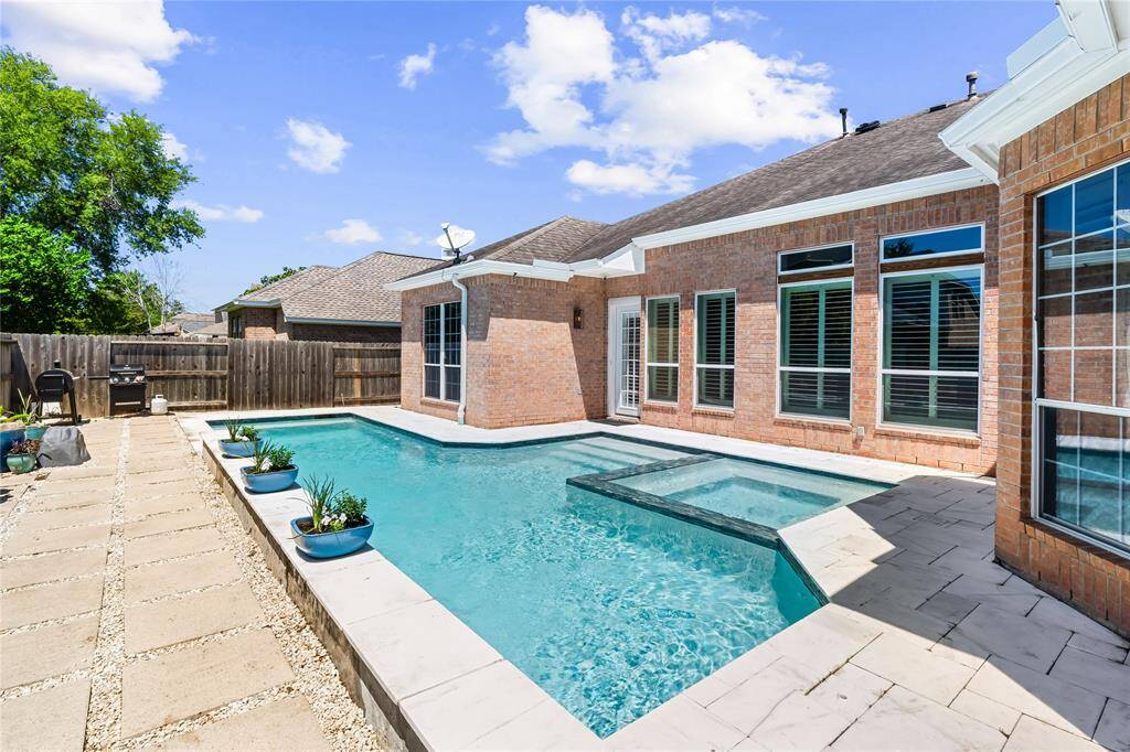 STEP OUTSIDE AND DIVE RIGHT INTO YOUR OWN BACKYARD OASIS - HEATED POOL AND SPA WITH WATERFALL FEATURES AND TRAVERTINE.