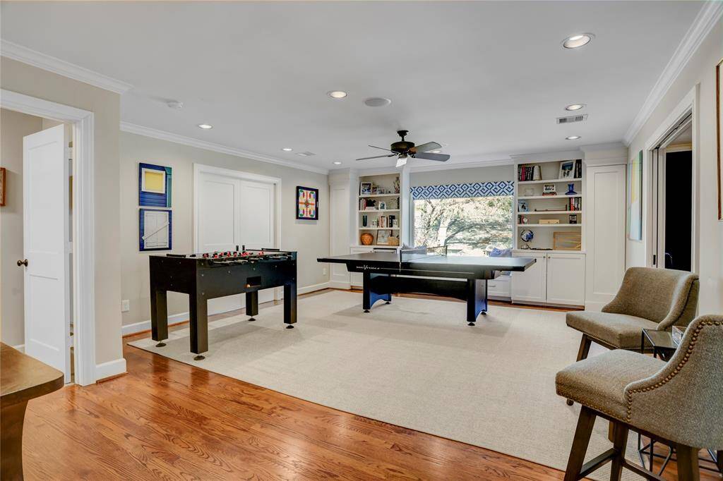The open game room has a beautiful picture window, more built-in storage including bench seating and a built-in drink cooler.  This room is truly the upstairs hub as it is easily accessed from the secondary bedrooms and directly connected to the media room and the workout/bonus room by double pocket doors.