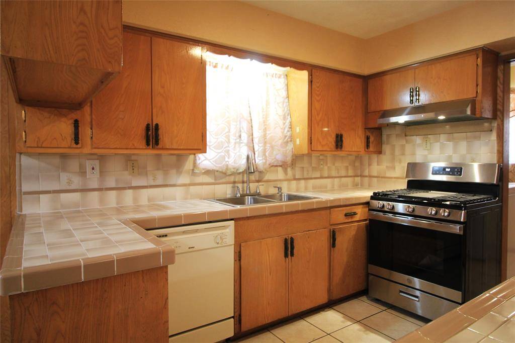 Kitchen appliances: Freestanding gas range, Dishwasher, vent hood, and electric wall oven