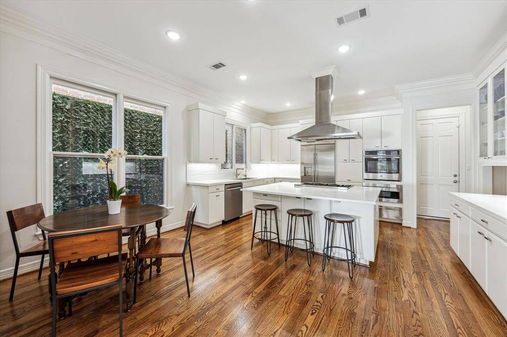 Spacious kitchen features breakfast nook, oversized island with bar seating, double ovens, large pantry, and endless storage.