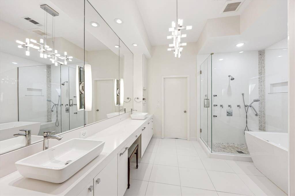 Primary bathroom features soaking tub, separate shower, double sinks, towel warmers, and large closet with his/her sides.