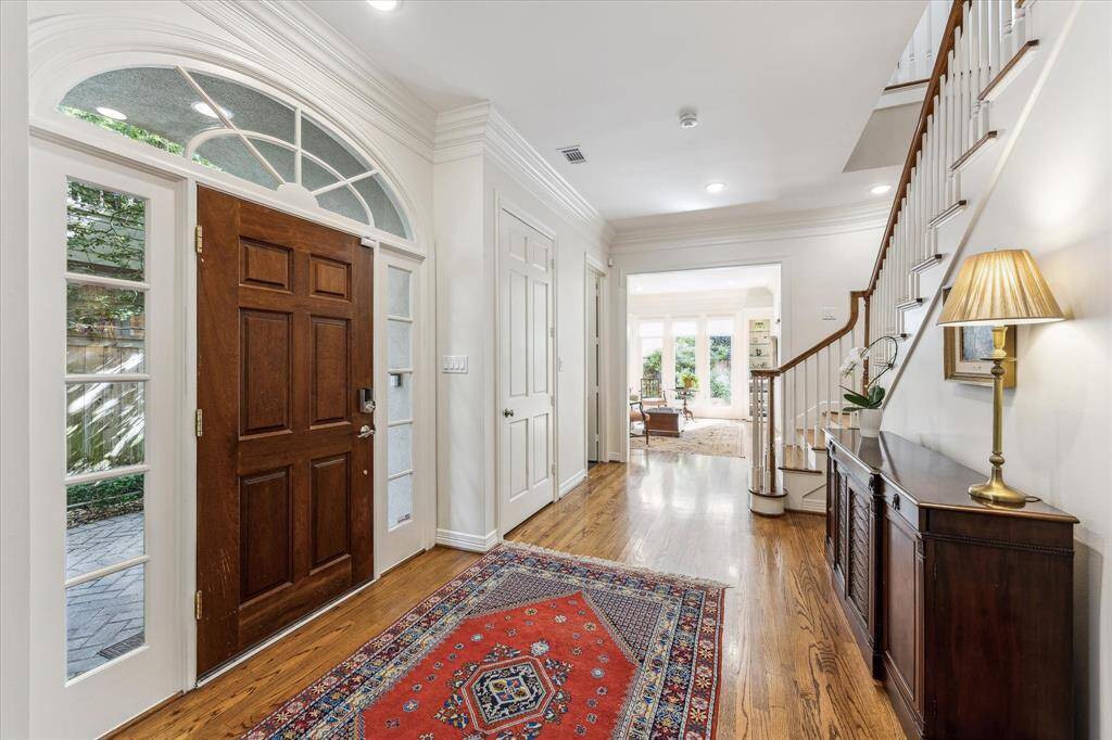 Foyer is welcoming with high ceilings and open to the formal dining room, living room, and access to the kitchen. Door to the right of the entry is the elevator shaft.
