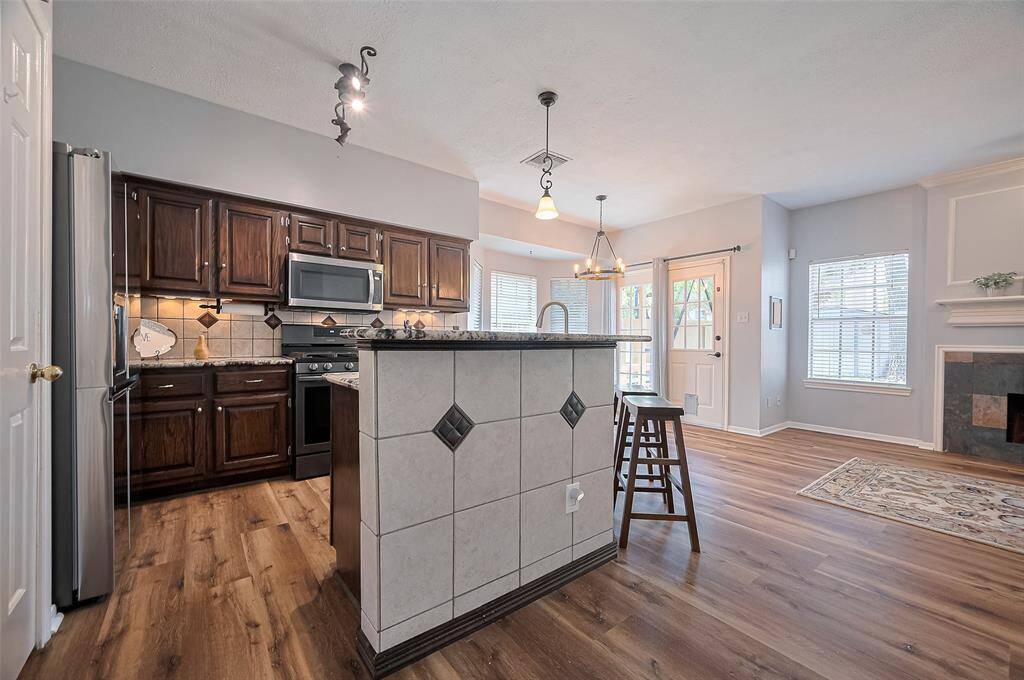 Granite breakfast bar with tile accents and ambient under-cabinet lighting.