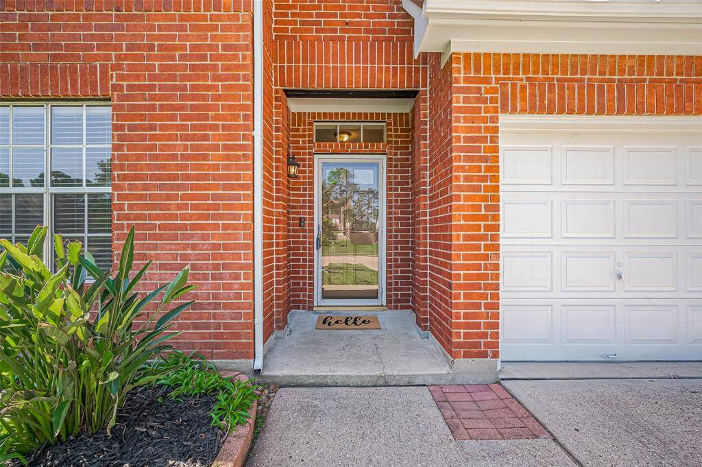 A welcoming entryway with an all-brick entry/exterior. lush landscape and well manicured lawn adds to the charm.