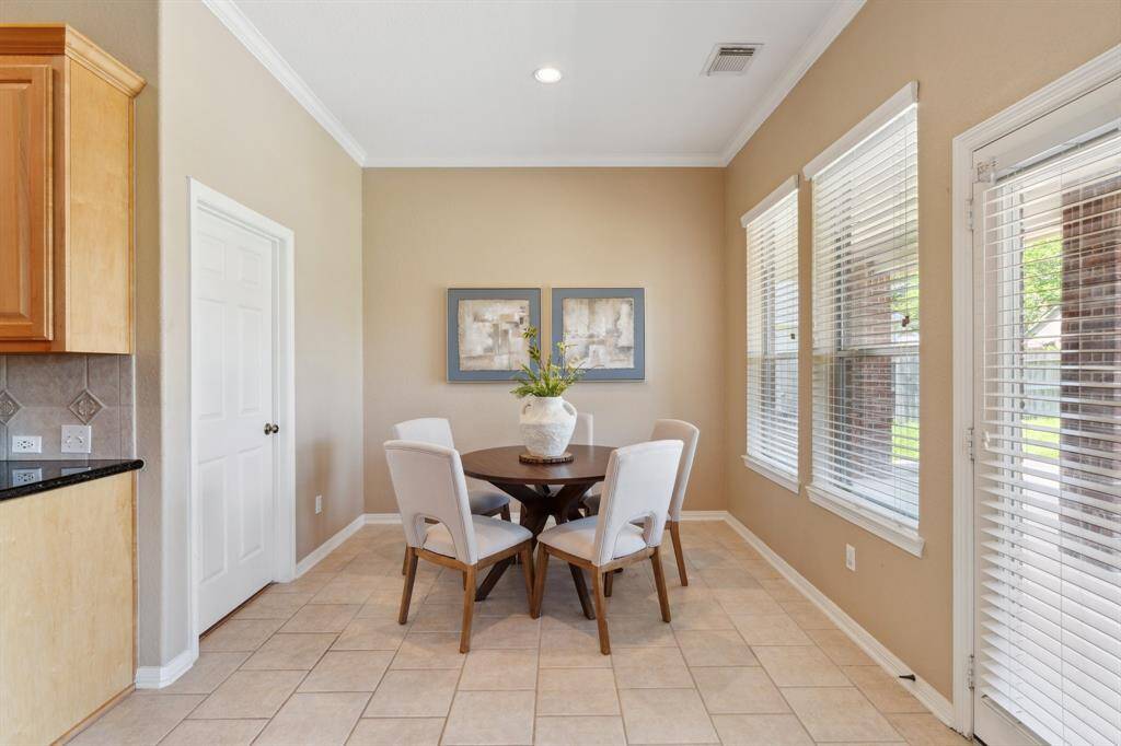The breakfast nook is tucked just off the kitchen, featuring large windows that let in natural light and offer a clear view of the backyard.
