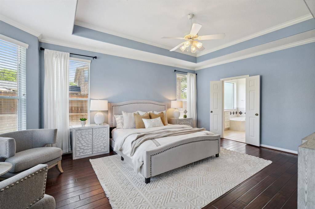 The spacious bedroom features a trayed ceiling, bay windows, and an ensuite bathroom.
