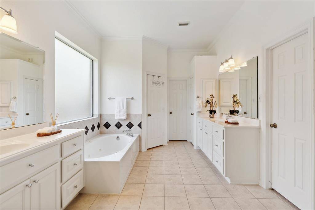 This spa-like bathroom boast double sinks, a separate shower, a soaking tub, water closet, and two walk-in closets.