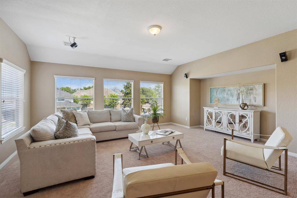 The spacious upstairs game room offers versatile space for lounging, play, or a home office.