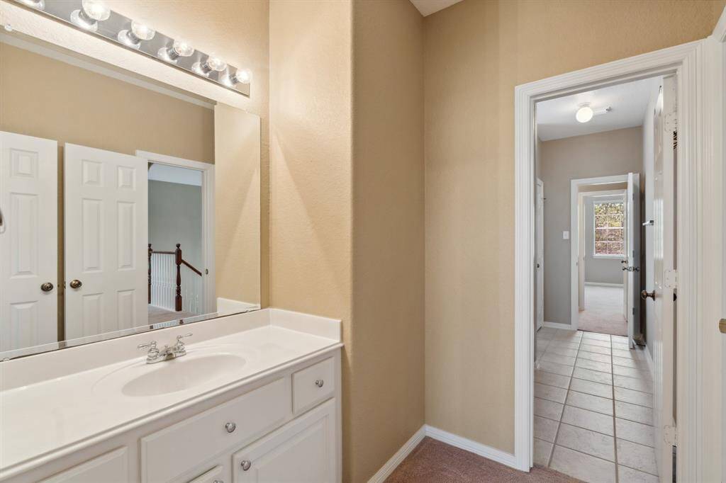 The opposite side of the Jack-and-Jill setup features a private vanity, with a shared tub-shower combo connecting the two sides in the center.