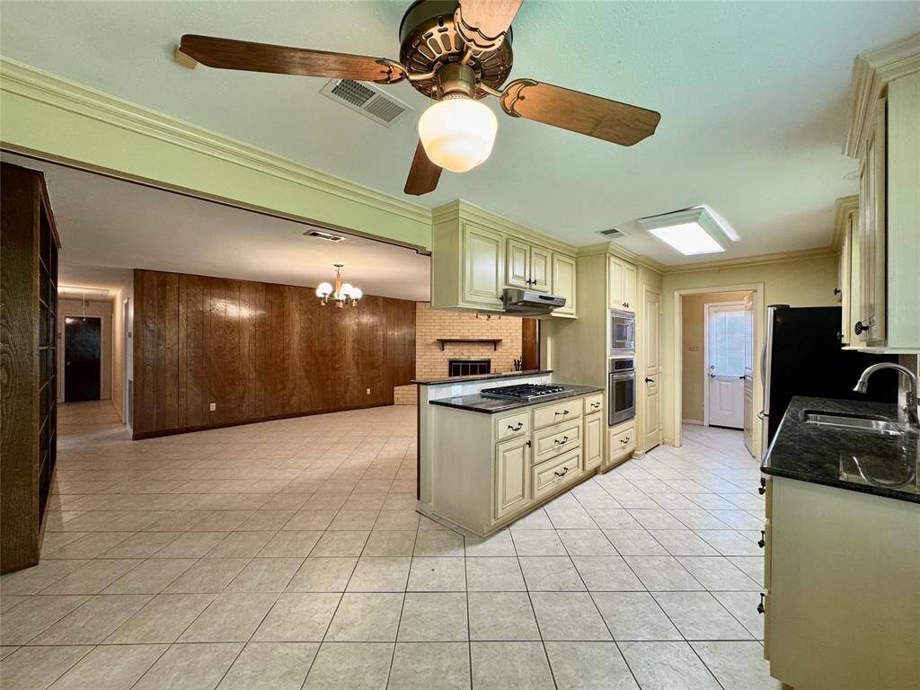 All stainless steel appliances in the kitchen, including gas stove, wall-mounted oven/microwave, dishwasher, and French door refrigerator.
