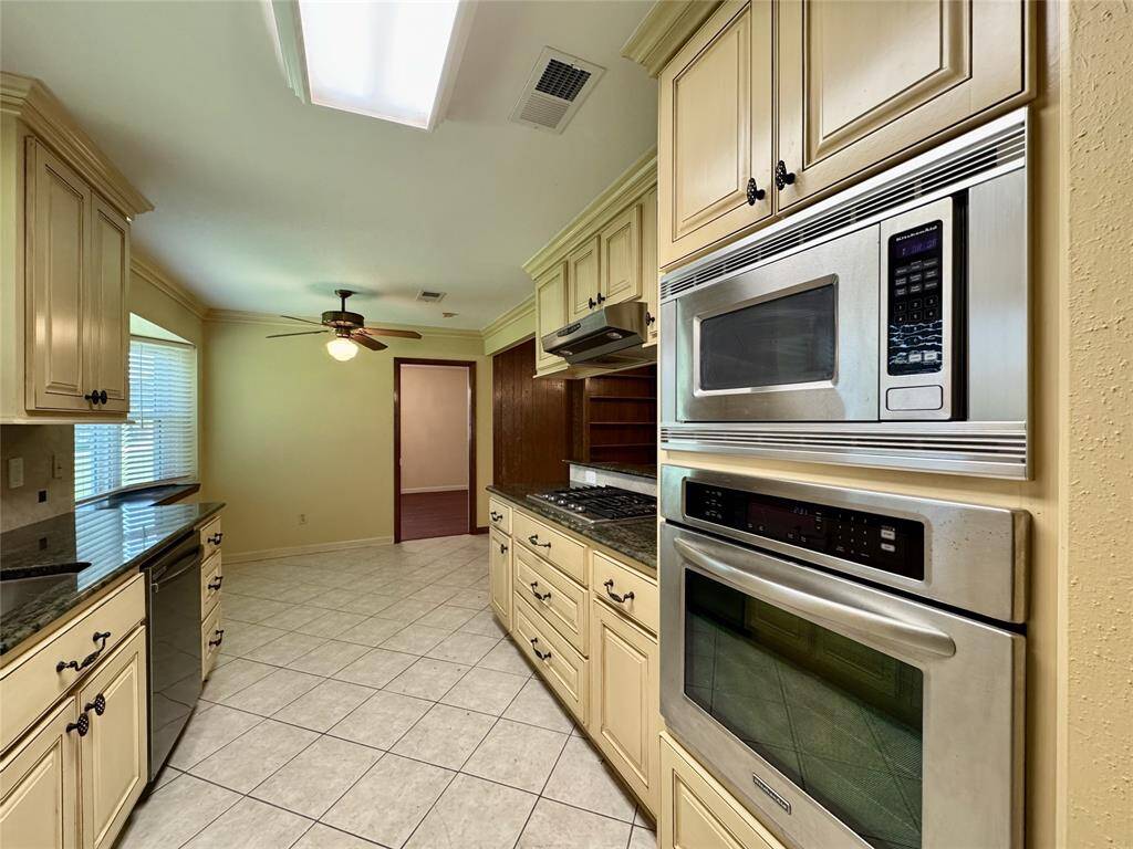 All stainless steel appliances in the kitchen, including gas stove, wall-mounted oven/microwave, dishwasher, and French door refrigerator.