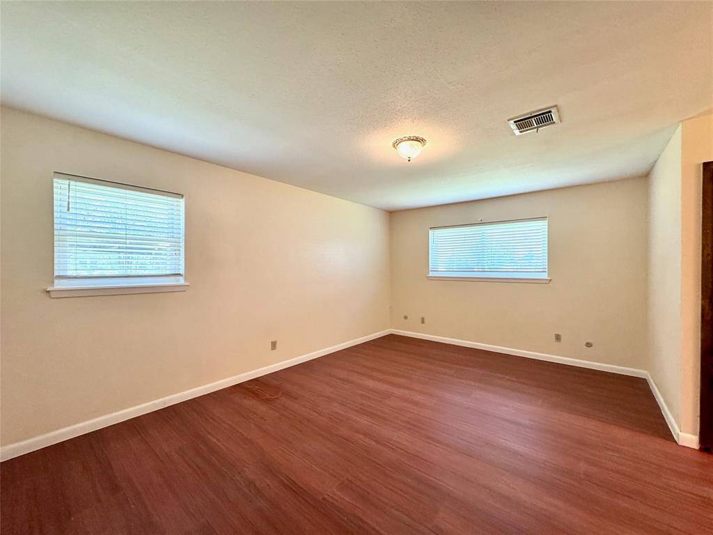 Large primary bedroom with luxury vinyl plank flooring.