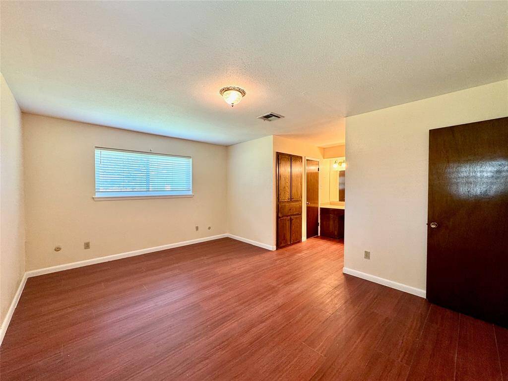 Large primary bedroom with luxury vinyl plank flooring.