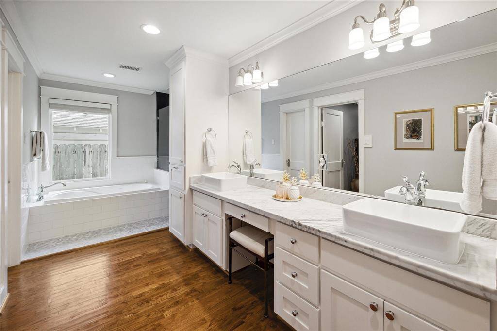 Spacious primary bath with marble counters, double sinks and plenty of countertop space and great storage.  To the left of the tub is a huge walk-in closet!