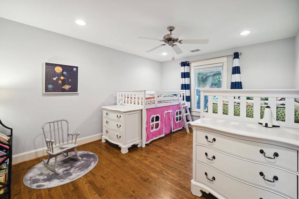 Spacious third bedroom on the 2nd floor with hardwood floors, recessed lighting, walk-in closet, ceiling fan and window coverings.