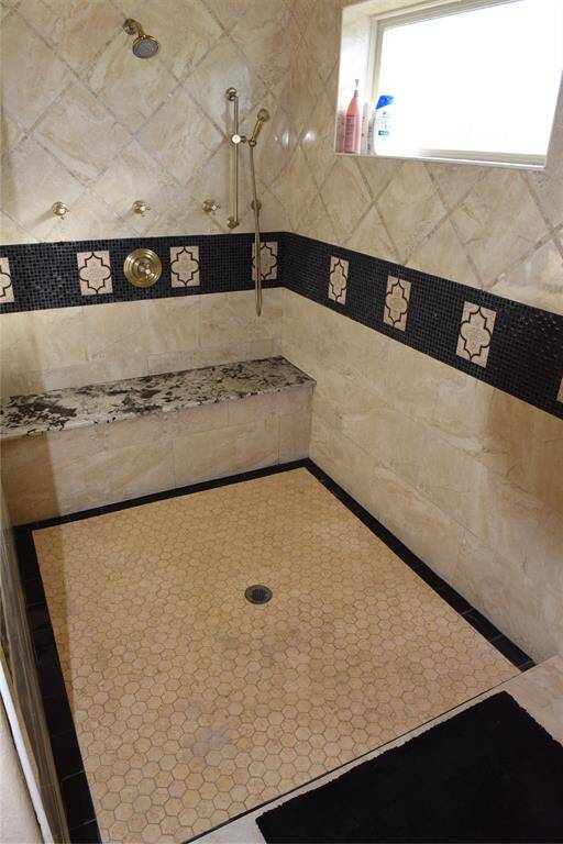 Antique white finish in primary bathroom, granite countertop, His sink, on porcelain floors, and knotting alder solid hard wood doors.