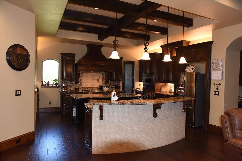 Living room with hickory  hard wood floors, gas fireplace, wood beams and custom-made wood blinds.