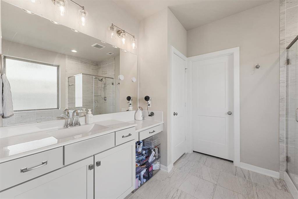 Get ready in style at the vanity in the Primary Bathroom. Room for storage in the linen closet.