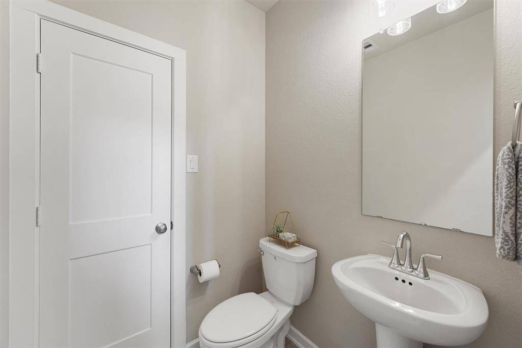 A half bathroom is conveniently located downstairs for your guests. You won't believe the size of the linen closet here. Plenty of storage for cleaning supplies and jumbo packs of paper goods!