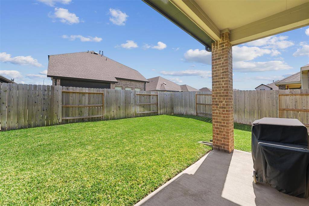 Covered patio overlooking a fenced in yard.