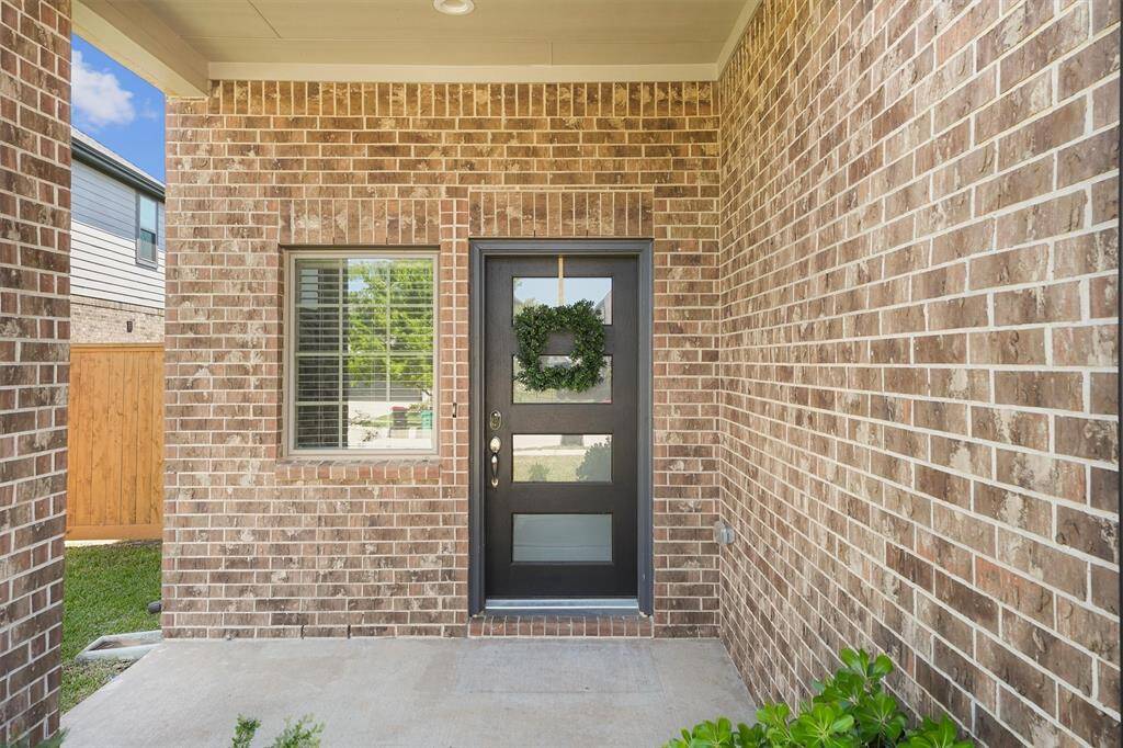 Welcome home! Beautiful modern door lets in natural light. Your packages will stay dry under the ample portico.