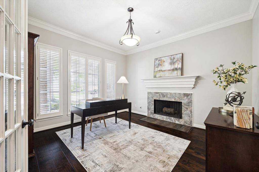 A private office or a great library space features glass-paneled french doors and a gas assist fireplace.
