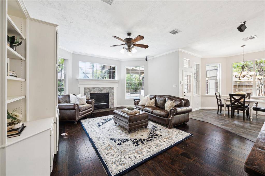 This spacious living room, adorned with a stunning fireplace and built-in shelving, invites both relaxation and sophisticated entertainment.