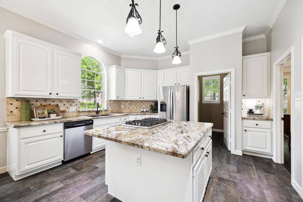 Large kitchen with stainless steel appliances, updated tile flooring, natural stone counters and white cabinetry makes this kitchen pop as light and bright!
