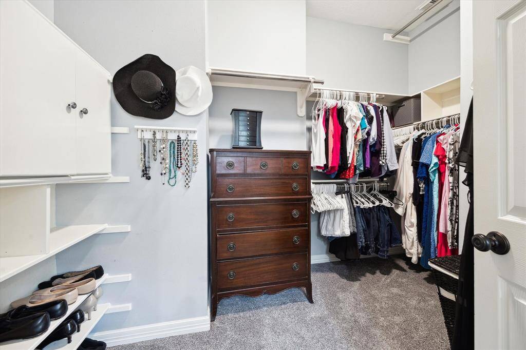 Another large primary closet with abundance of shelving and storage