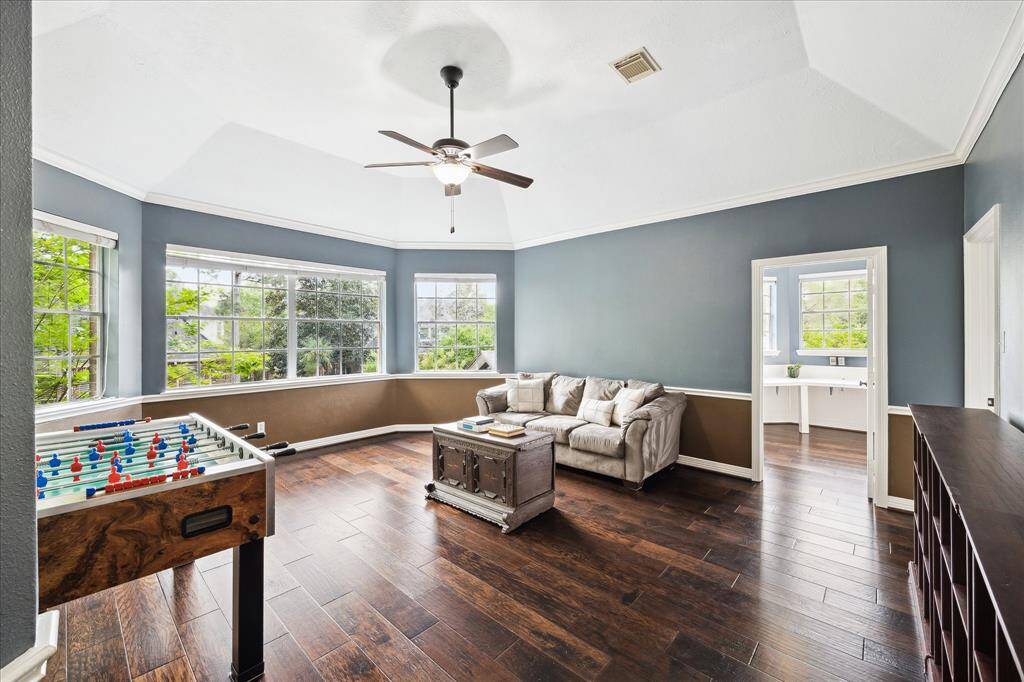 Game room with wood floors, many windows and plenty of space for entertaining