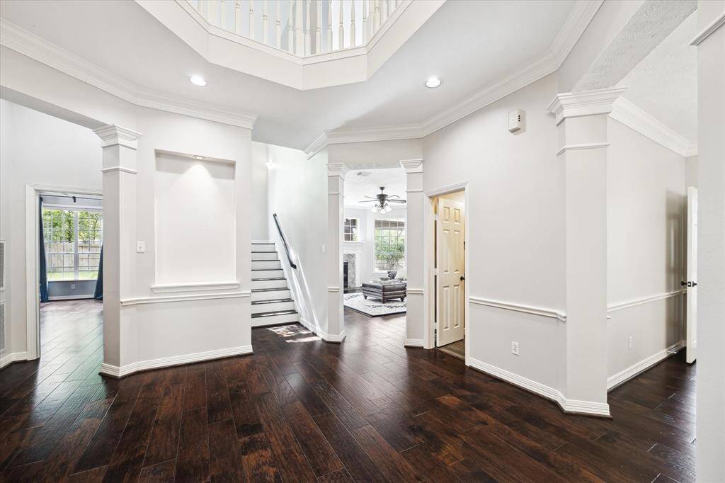 Spacious entry with wood floors that carry upstairs and throughout the downstairs living areas, with the exception of the kitchen, utility, and primary bath. The home feels light and bright with fresh paint.