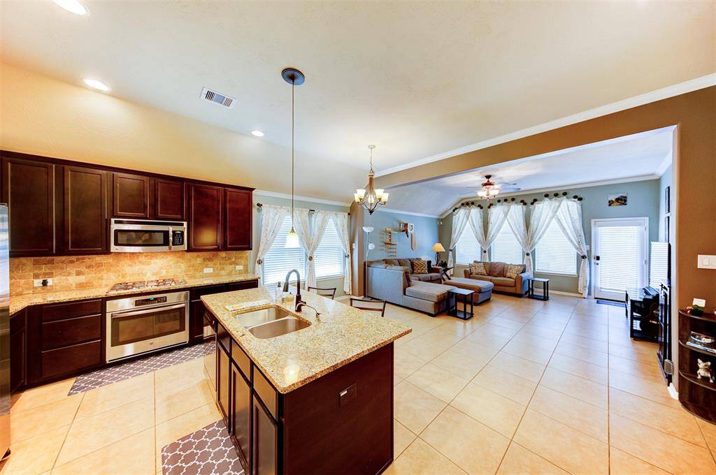 The kitchen is the center of the home featuring granite counters, stainless appliances & tumbled marble backsplash